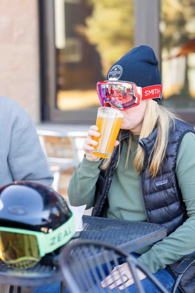 Snowboarder drinking a beer during Happy Hour at Kickstand Kafe